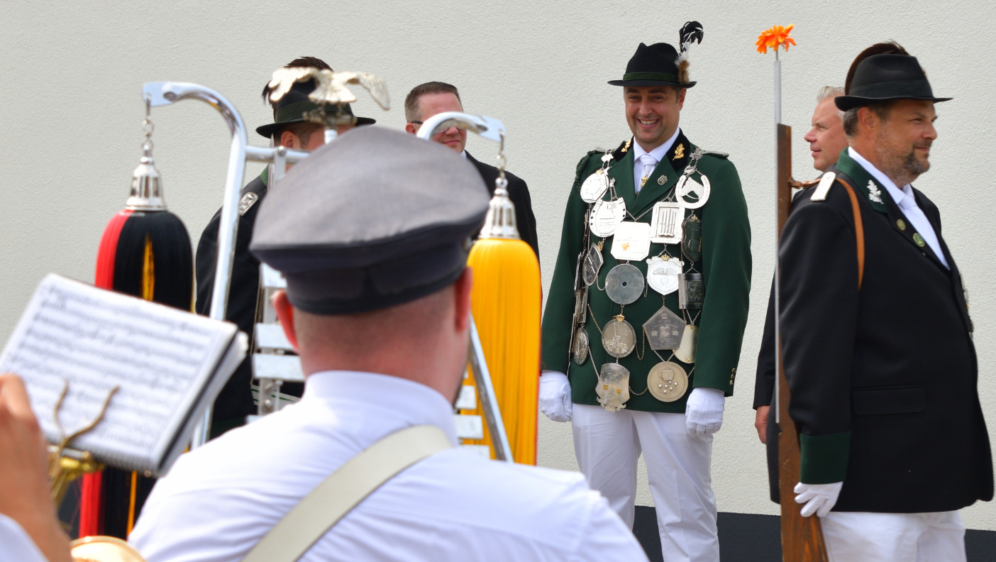 Unser Schützenkönig freute sich deutlich sichtbar über die mu­si­ka­lische Um­rah­mung der Feier und die vielen gratu­lie­rend und salu­tie­rend an ihm vorbei­ziehen­den Schützen­brüder.