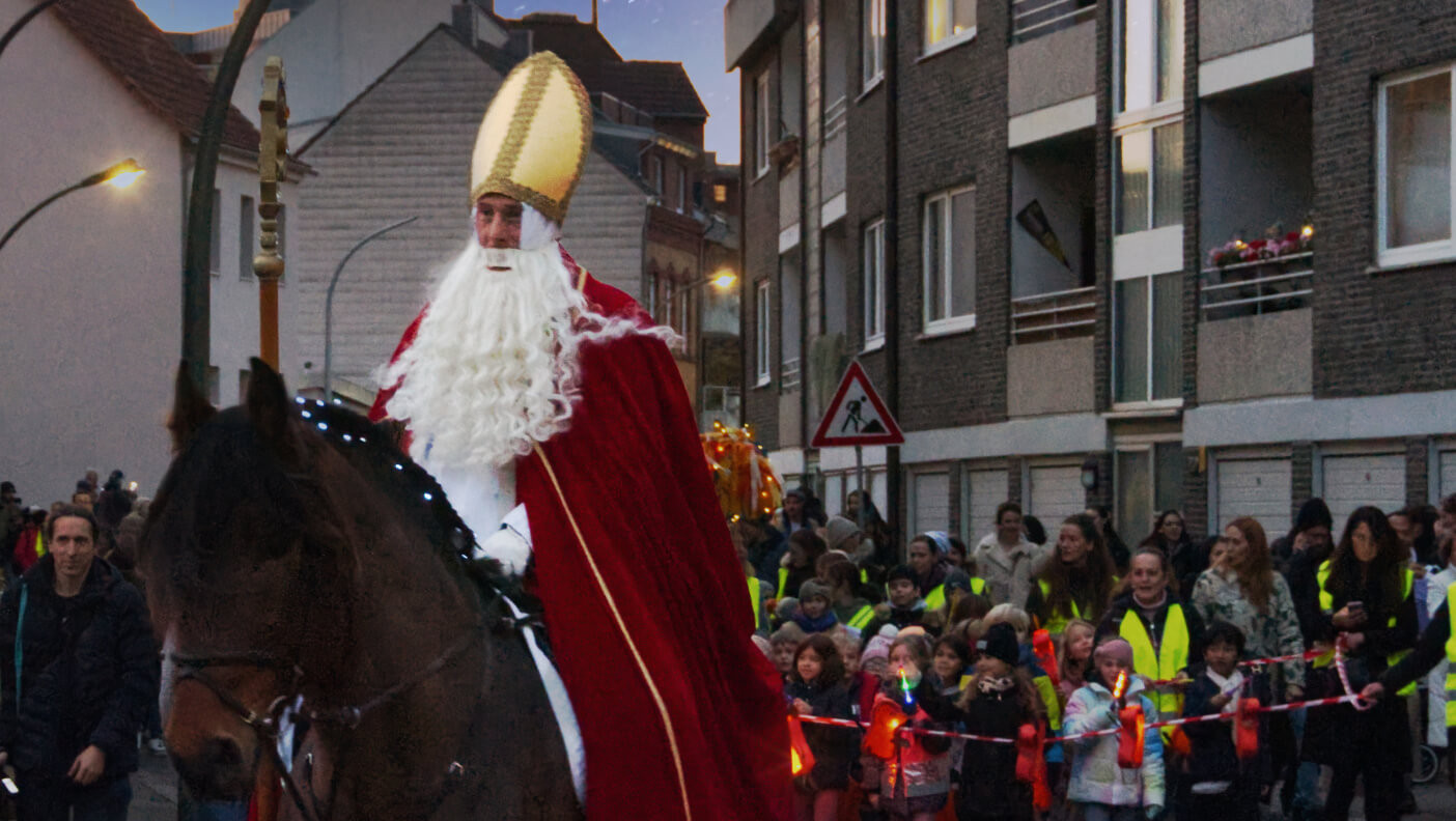 Brauchtum, Lieder und Laternenzug: Der Martinszug durch Flehe wird traditionell durch den hl. Martin als Bischof auf einem Pferd reitend angeführt.
